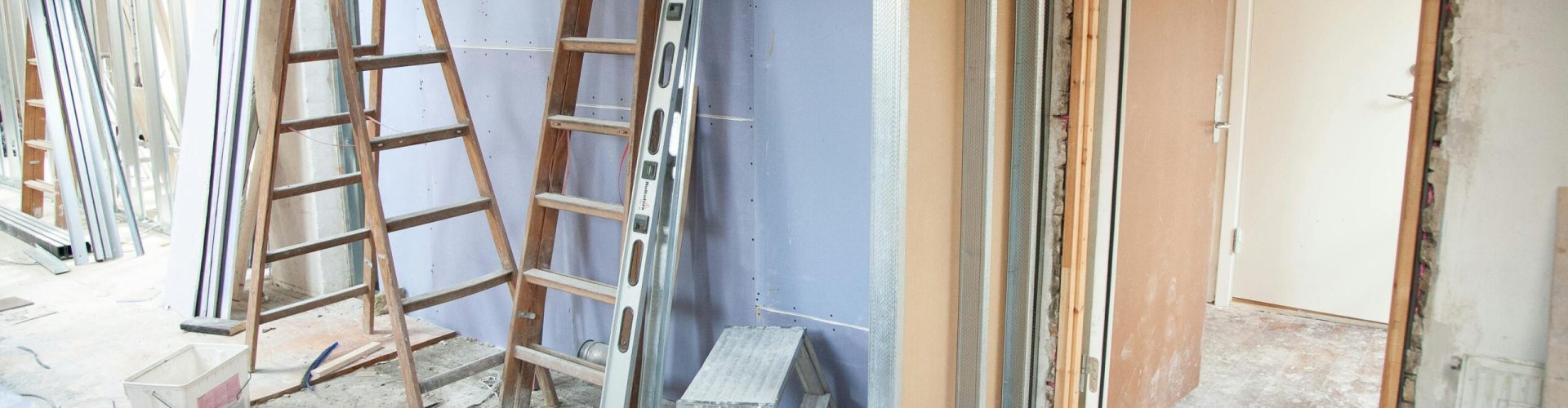 Construction site featuring ladders and tools in a home renovation setting.